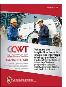Image of cover of report. Photo is of two workers in yellow hard hats inspecting machinery.