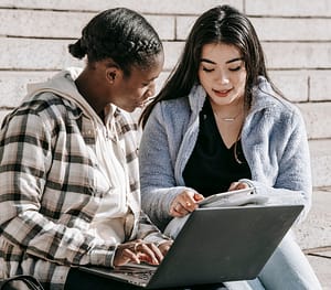 Decorative image of two people looking at a notebook