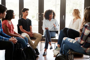 Decorative image of people sitting on chairs in a circle
