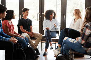 Decorative image of people sitting on chairs in a circle